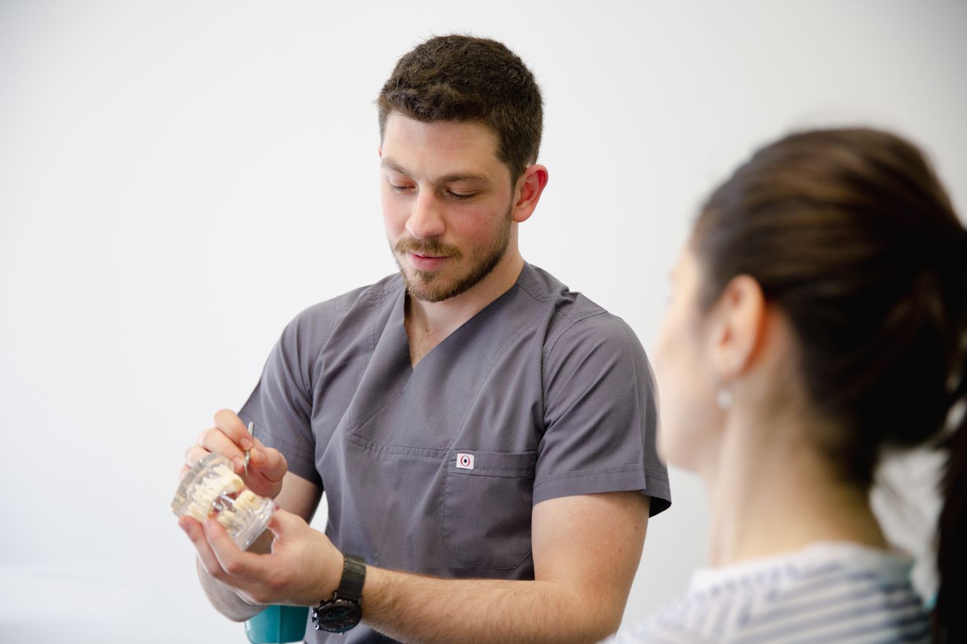 Orthodontiste expliquant un appareil dentaire avec un modèle lors d’une consultation