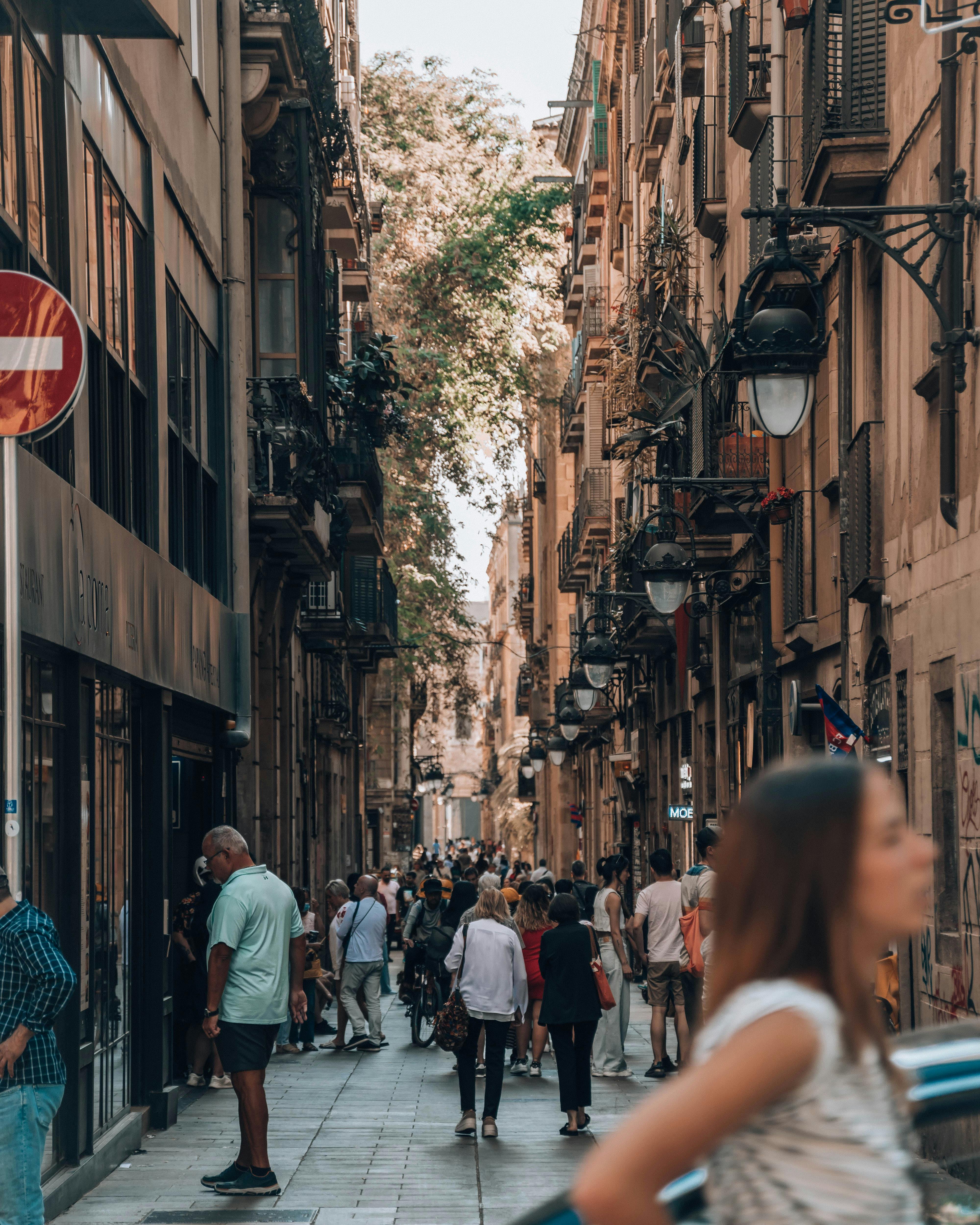 people walking on the street beside brown concrete buildings