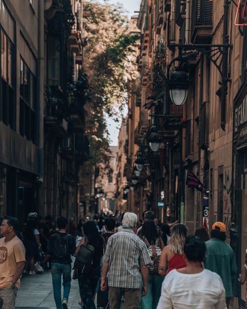 Free Vibrant street in Barcelona with people walking and historic buildings in the background. Stock Photo