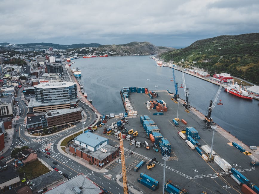 Aerial overhead view of a busy city port with cargo containers, cranes, roads, and waterfront, reflecting the dynamic logistics environment essential for supply chain professionals.. πΈ: Erik Mclean