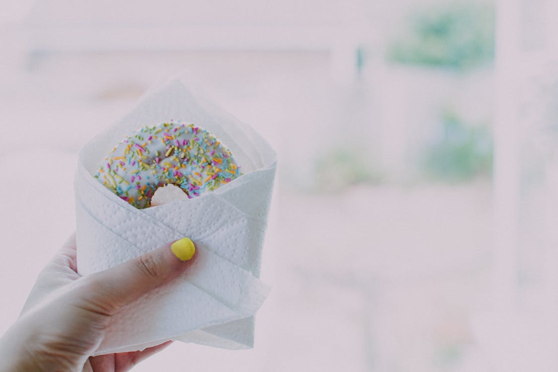 Frau, Die Donut Mit Streuseln Hält