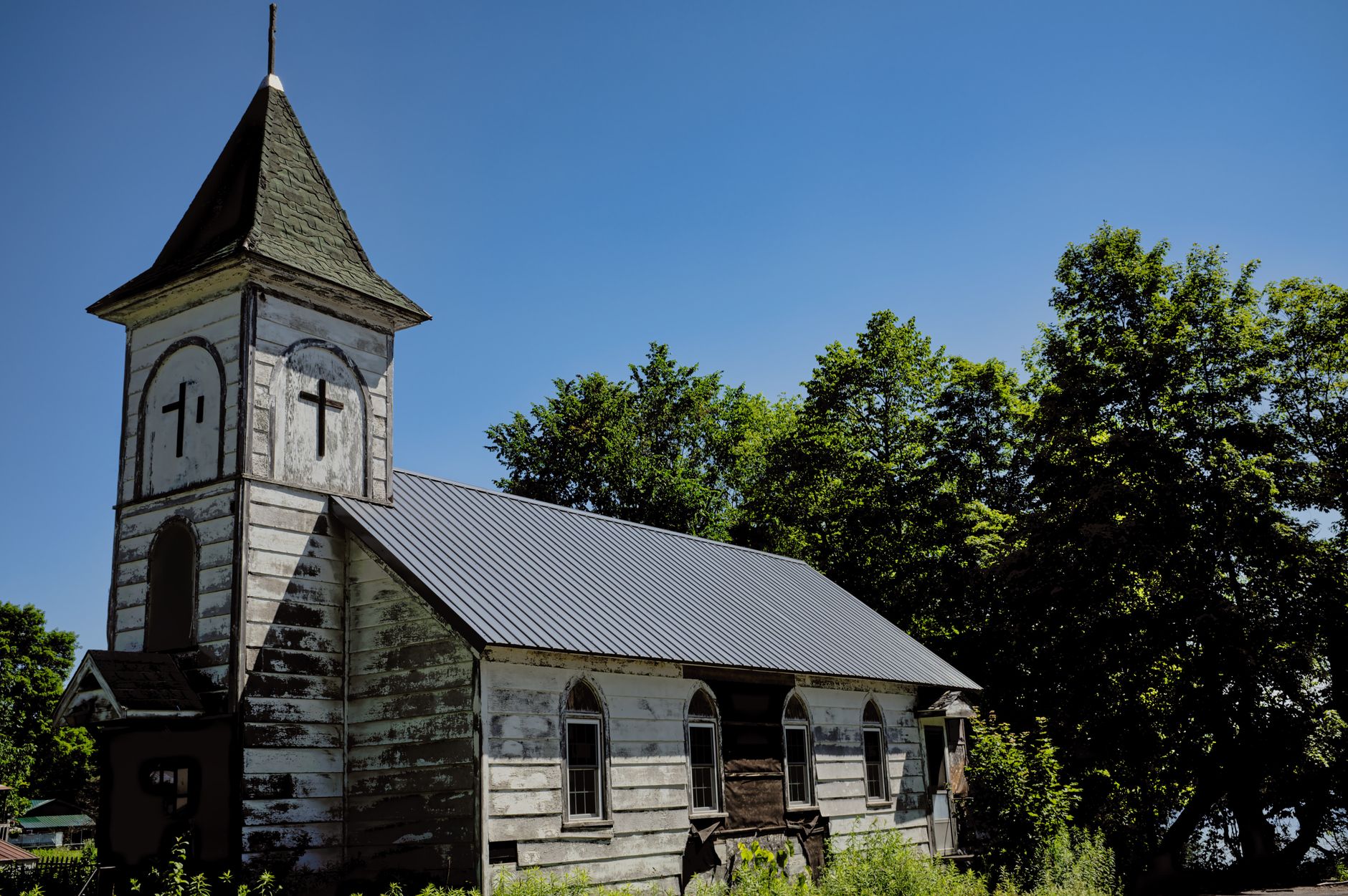 Old wooden chapel with weathered exterior, surrounded by trees in rural Redfield, NY.