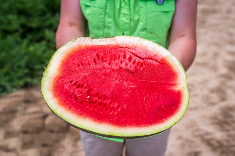 A Person Holding A Sliced Watermelon