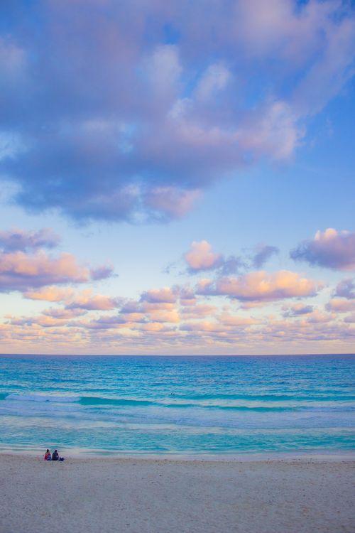 Free A tranquil beach view in Cancún with blue skies and gentle waves. Ideal for travel and nature themes. Stock Photo