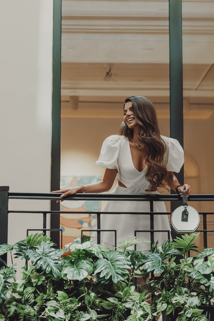 Beautiful Woman In White Dress Standing On The Balcony 