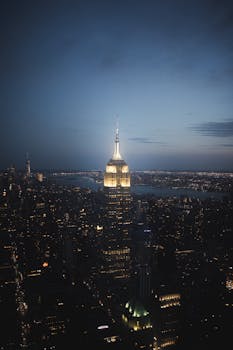 Stunning aerial view of the illuminated New York City skyline featuring the Empire State Building at night.