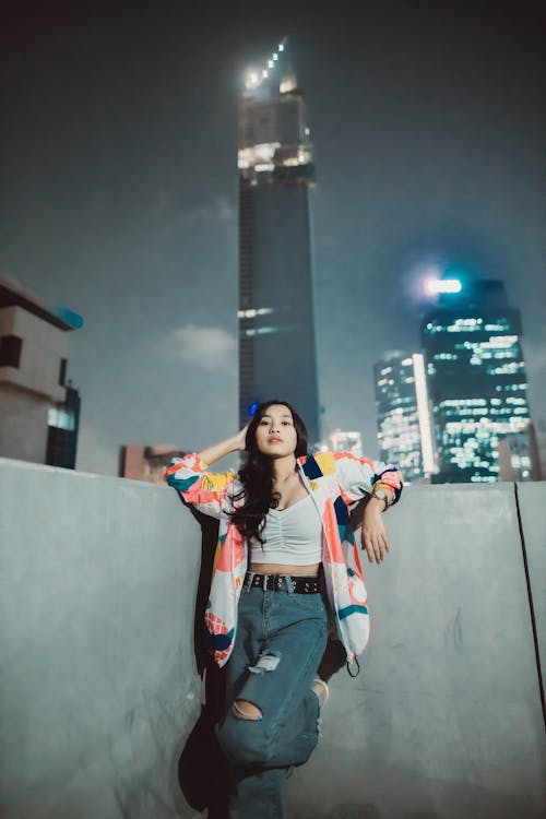 Woman Fashion Model Posing at Wall with City in Background