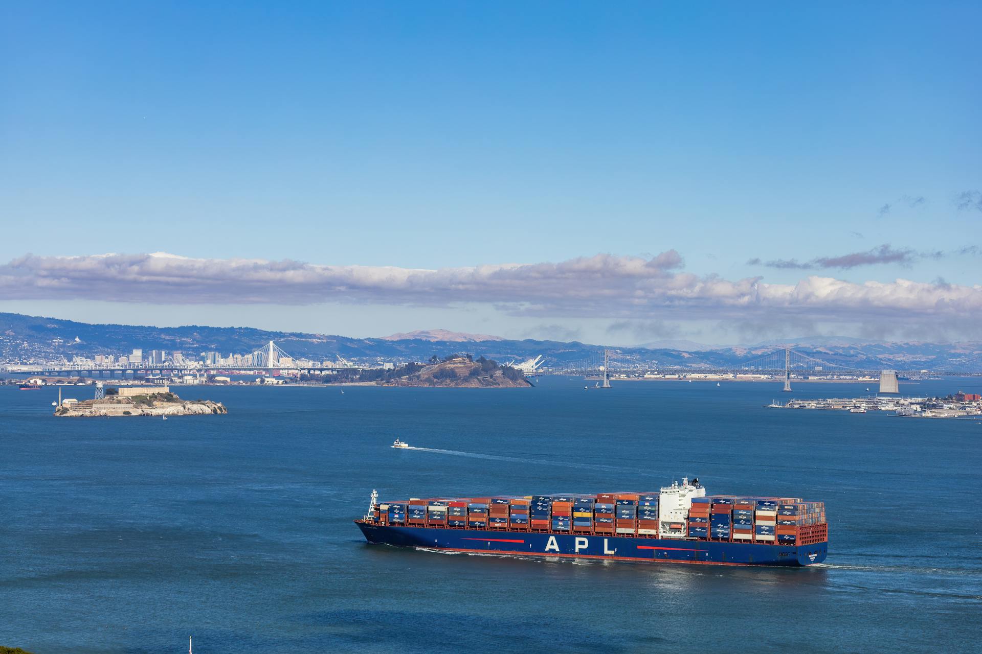 Container ship sailing in San Francisco Bay with Alcatraz Island in the background.