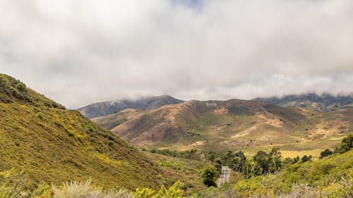 An Aerial Photography of Green Mountains Under the White Sky