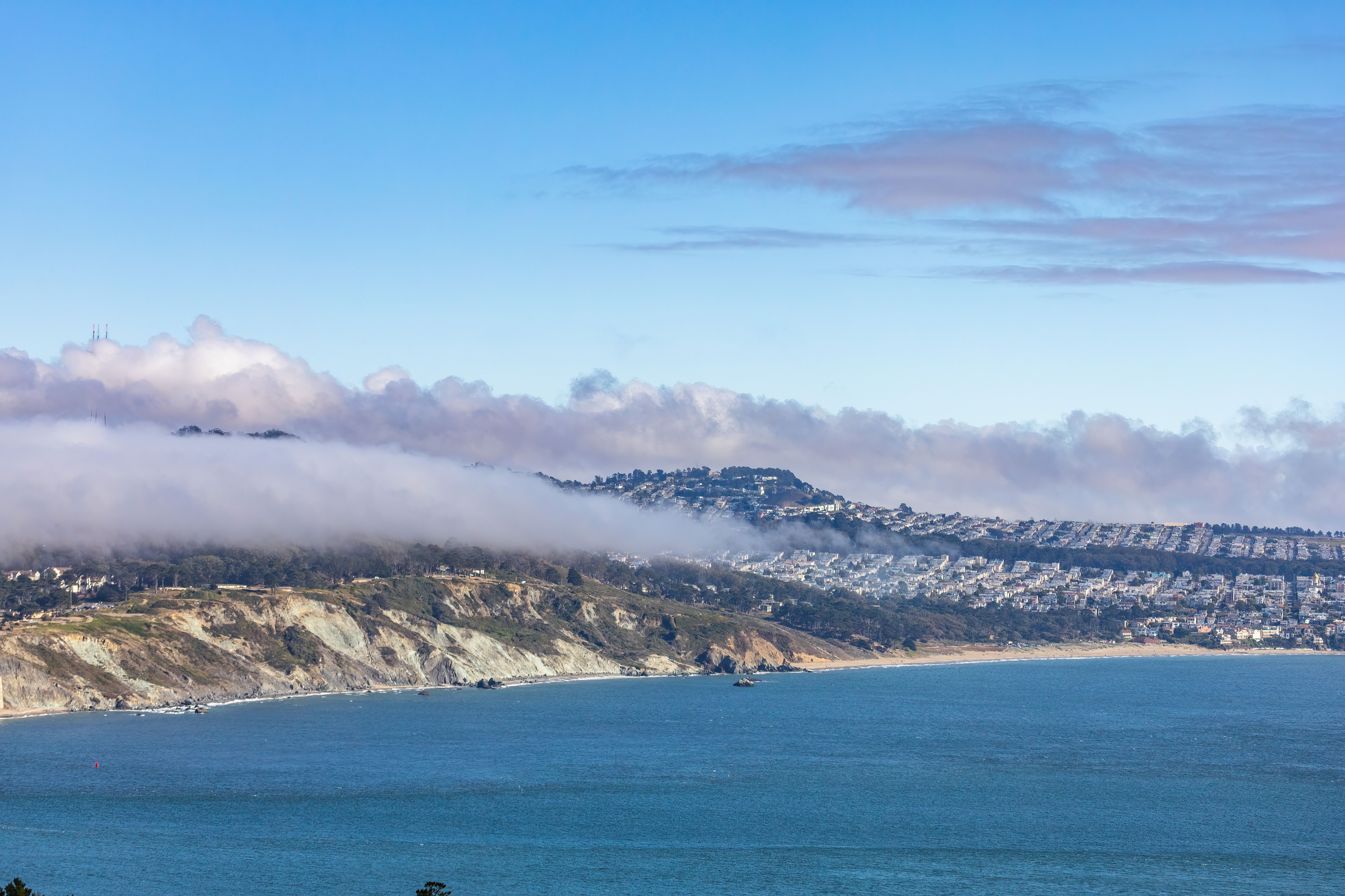 Oakland hillside home surrounded by fog rolling in from San Francisco Bay highlighting natural moisture risks
