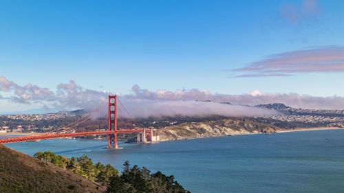 Free Stunning view of the Golden Gate Bridge surrounded by fog and under a clear blue sky. Stock Photo