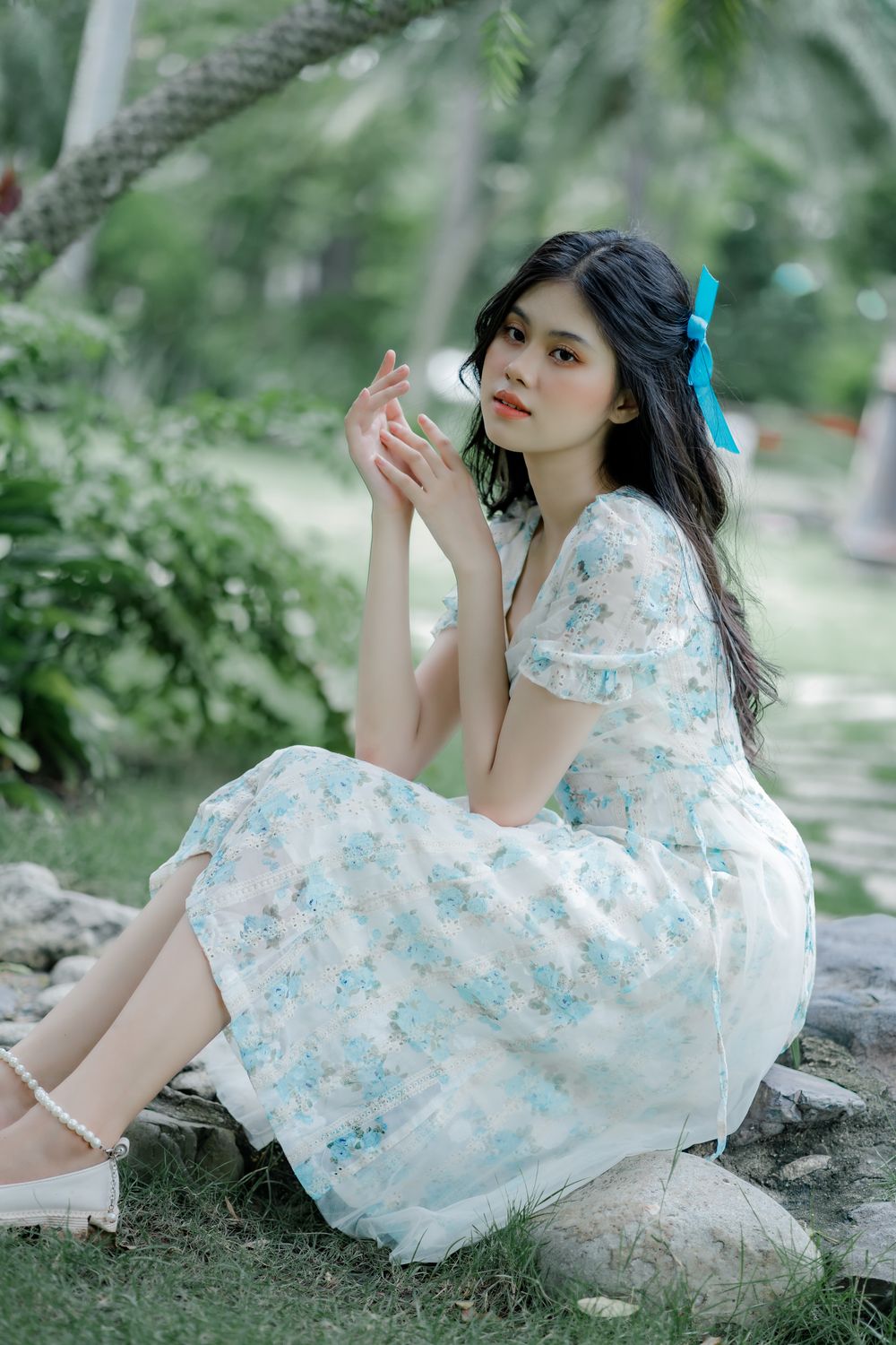 A Woman in White and Blue Dress Sitting on Gray Rock · Free Stock Photo