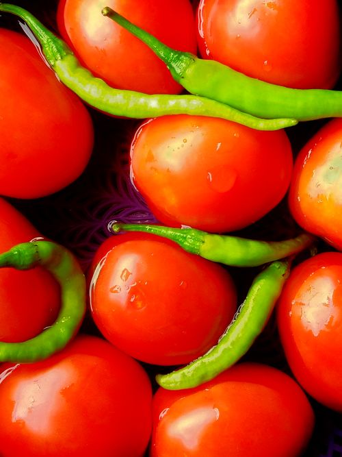 Free Vibrant close-up of fresh red tomatoes and green chili peppers with water droplets. Stock Photo