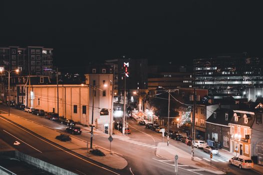 Aerial view of a vibrant urban street illuminated with night lights, showcasing city life.