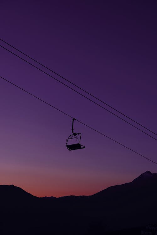 Silhouette of a Ski Lift over Mountains at Dusk 