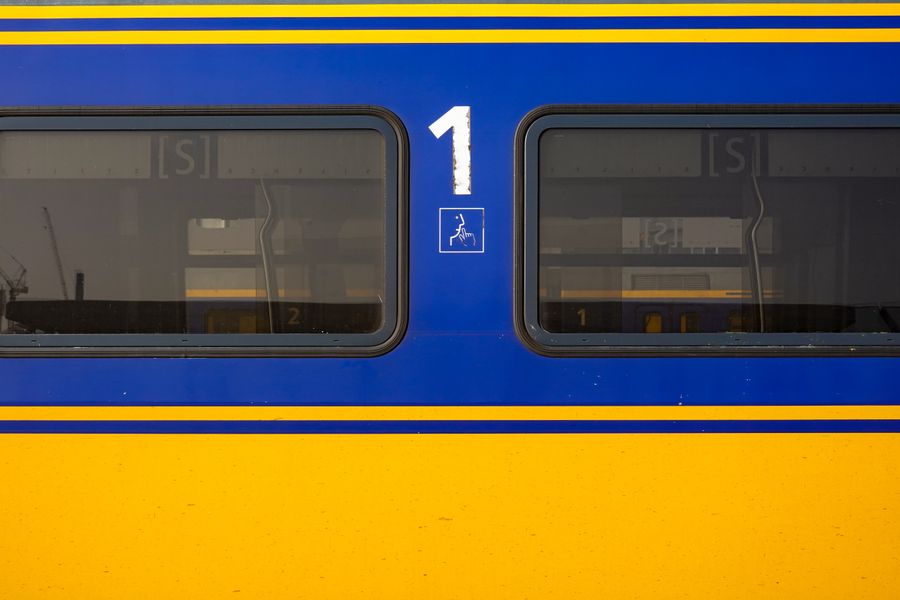 Detailed view of a blue and yellow train window displaying the number one.