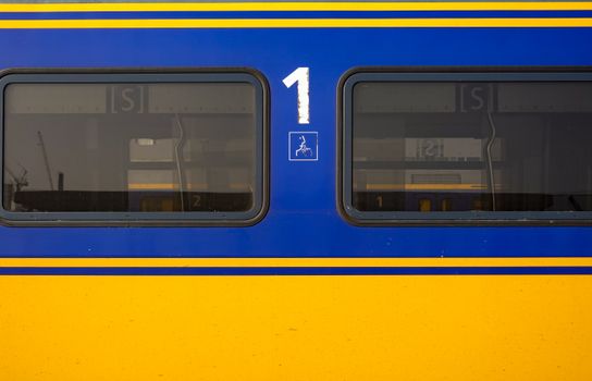 Detailed view of a blue and yellow train window displaying the number one.