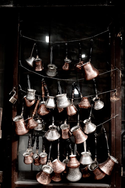 Brass and Silver Kettles Hanging on a Rack