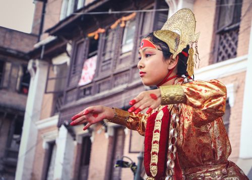 Free Young girl in vibrant traditional wear dancing at a Nepali festival. Stock Photo