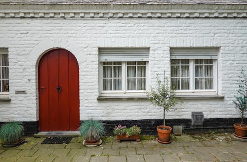 A Wooden Door and Glass Windows on a Brick Wall