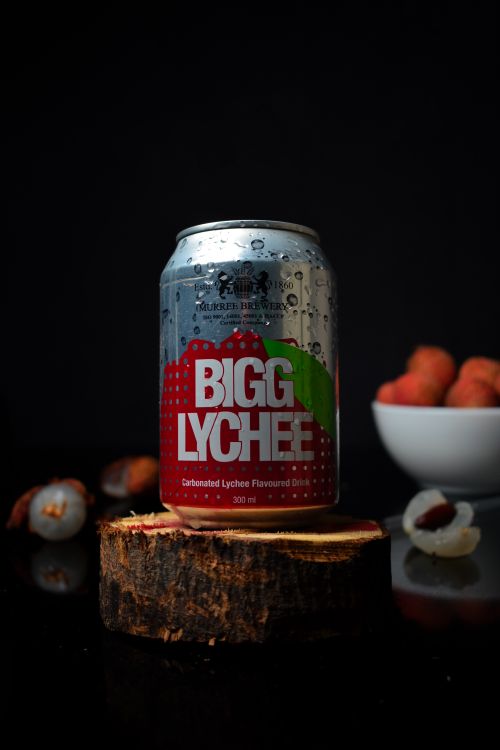 Free Close-up of a lychee flavored drink can with fresh lychees on a black background. Stock Photo
