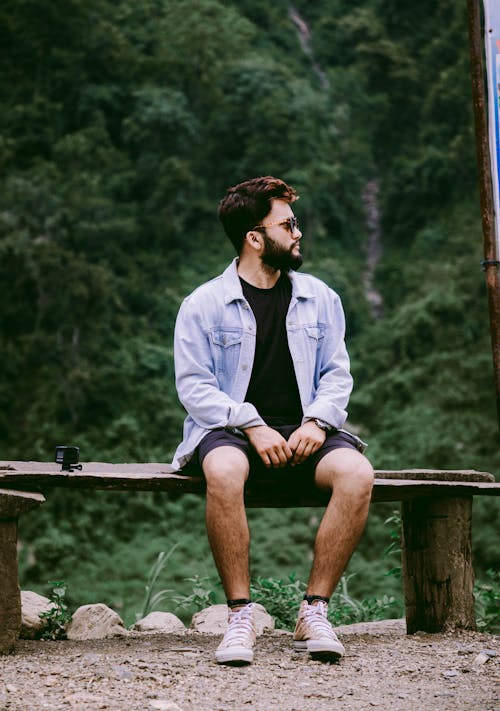 A Man in Sunglasses Sitting on the Bench