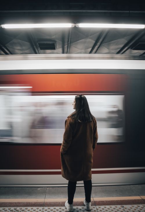 Free A woman stands on an İzmir subway platform as a train speeds by. Stock Photo