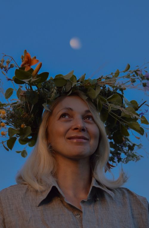 Free Smiling woman with flower crown under a twilight sky during summer festival in Ukraine. Stock Photo