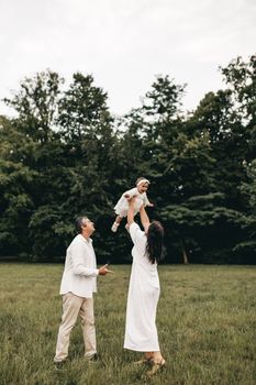 A family enjoying a fun day in the park with their baby, expressing joy and love.