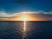 令人惊叹的日落映照在平静的海面上，海洋与充满活力的色彩相互辉映