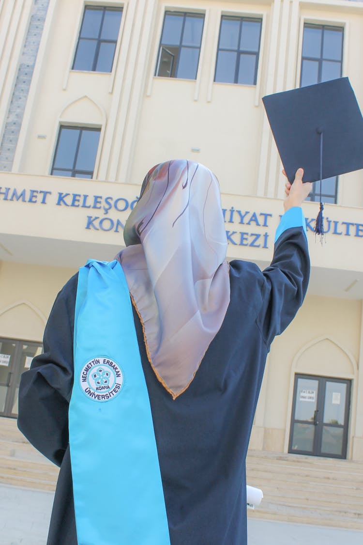 A Person Holding A Graduation Hat