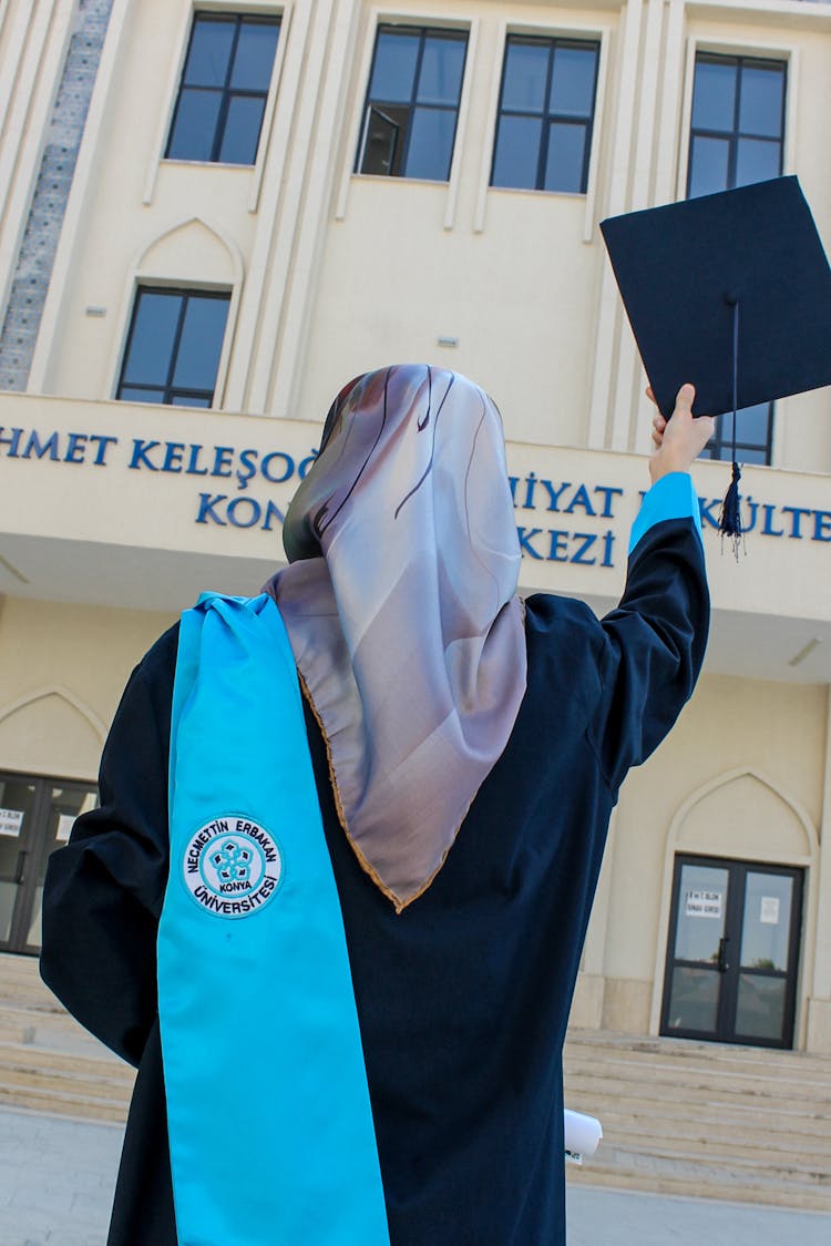 A Person Holding A Graduation Hat