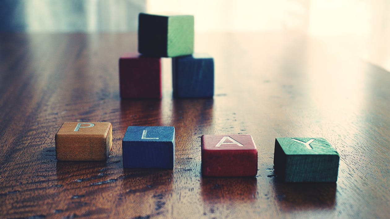Free Conceptual Photo of Word "play" Spelled by wooden Blocks. Stock Photo