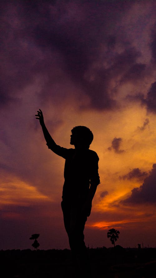 Free Silhouette of a Person Raising Hand Stock Photo