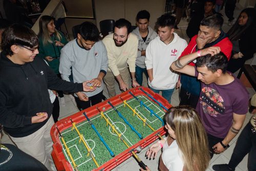 Free A lively group of friends gathered around a foosball table, engaging in a fun indoor game. Stock Photo