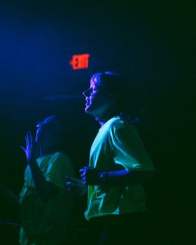Vibrant indoor party scene with two women enjoying the night under neon lights.