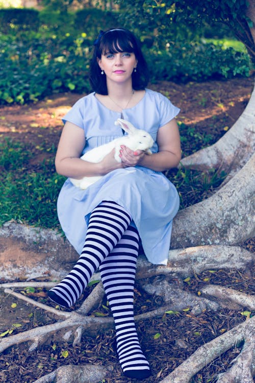 Woman in a Blue Dress Holding a White Rabbit 