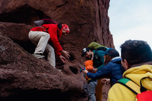 Photo of a Child Hiker Climbing Up on the Rock