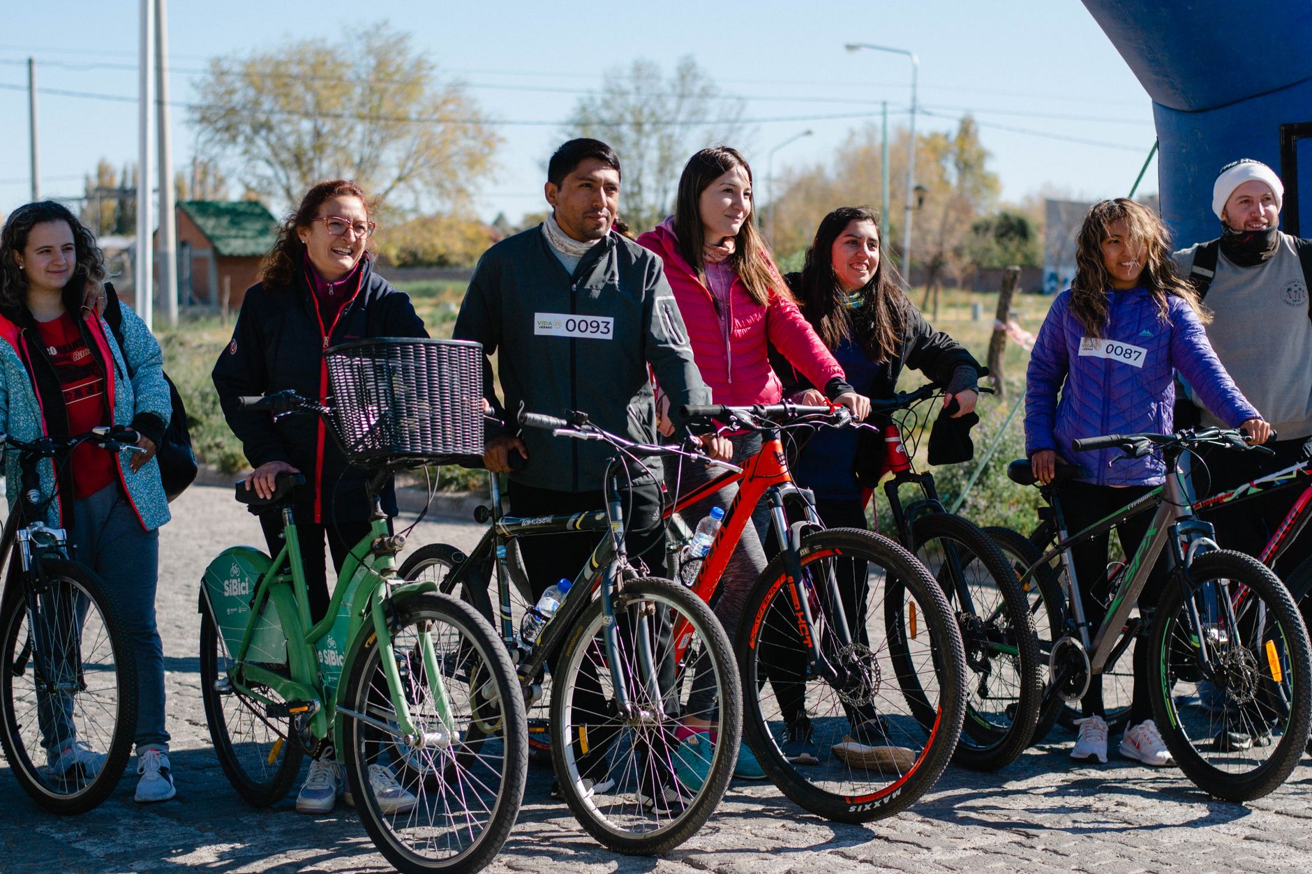 A diverse group of people with bicycles enjoying a sunny day outdoors