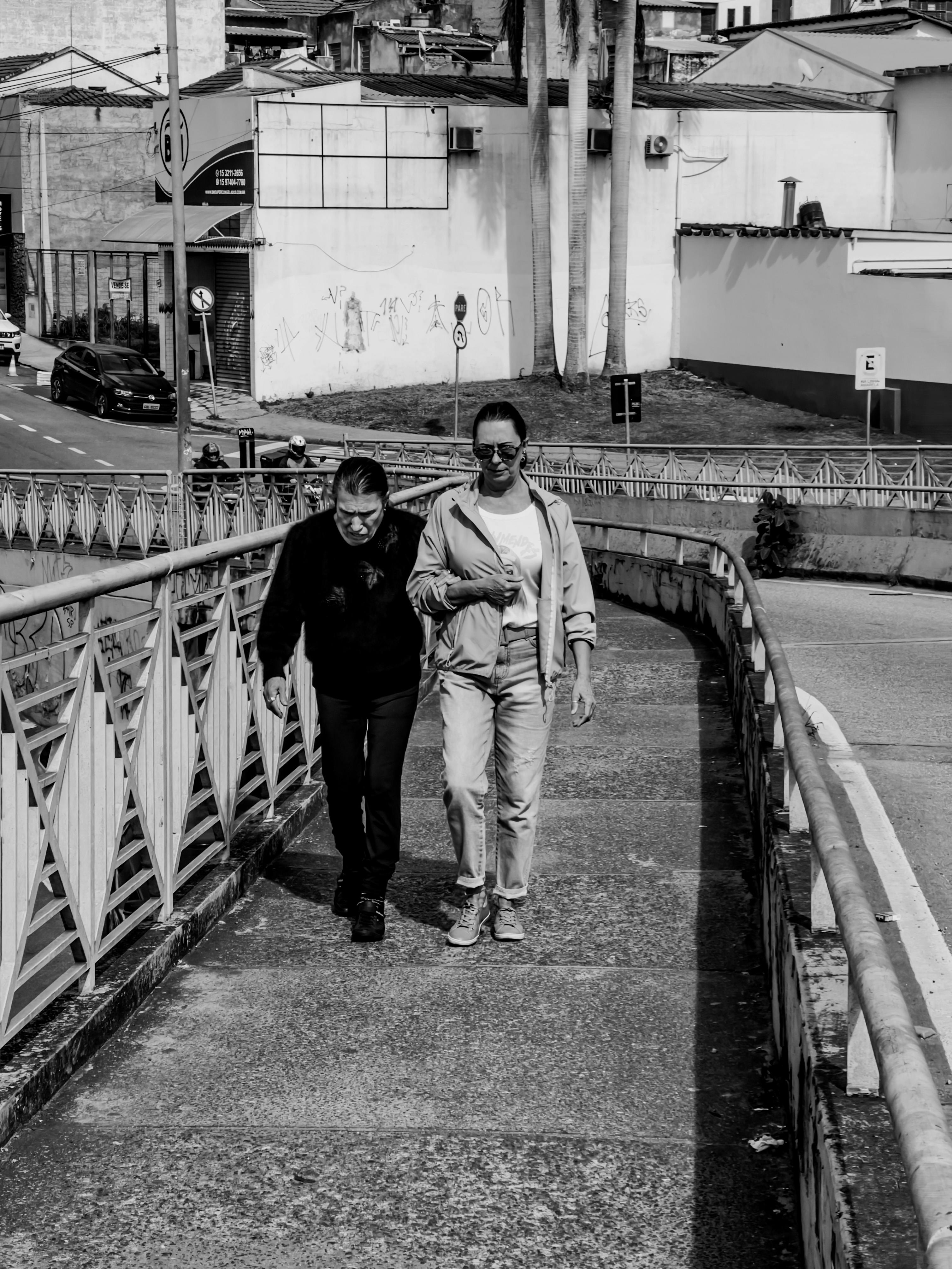 a caregiver guiding an elderly man while walking outdoors