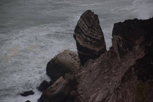 Free High-angle view of rugged cliffs and ocean waves. Ideal for nature and travel themes. Stock Photo