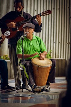 Musicians perform with drum and guitar in Venezuela, showcasing Latin rhythms and energy.