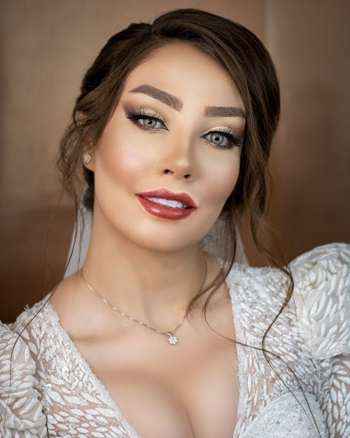 Free Close-up portrait of a woman with elegant makeup, styled hair, and white attire, exuding beauty and confidence. Stock Photo