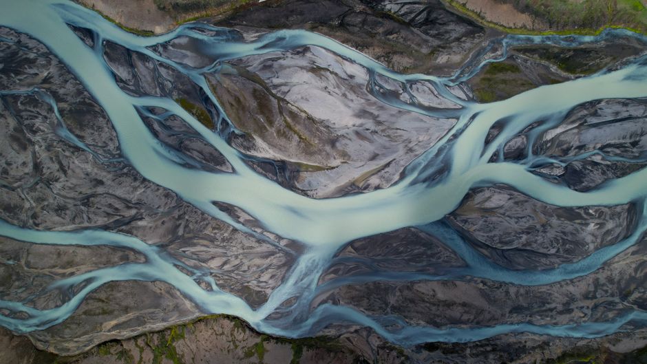 A breathtaking aerial photograph capturing the intricate patterns of glacier rivers flowing through Iceland's rugged landscape.