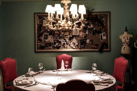 A sophisticated dining setup with a chandelier and red chairs in Shanghai.