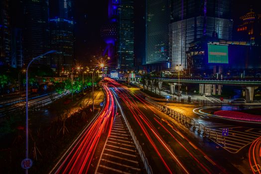 Vibrant night scene of Shanghai's cityscape with dynamic light trails and skyscrapers.
