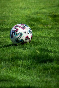 Close-up of a colorful soccer ball on a lush green grass field.