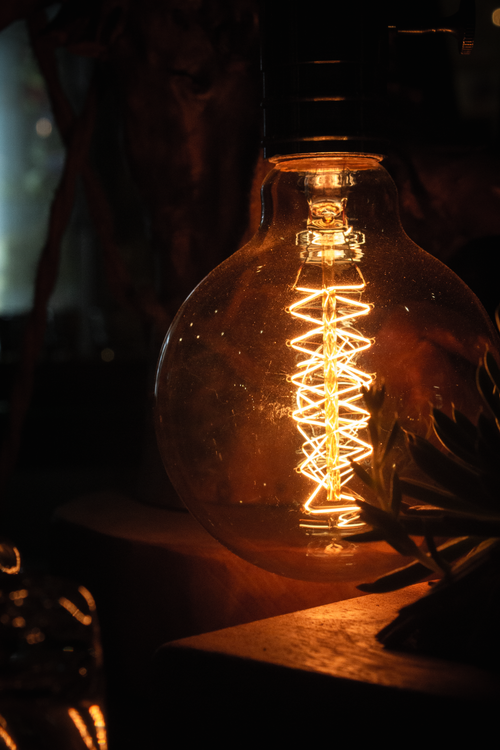 Free A glowing filament captures the warmth and elegance of classic lighting in this moody photo. Stock Photo