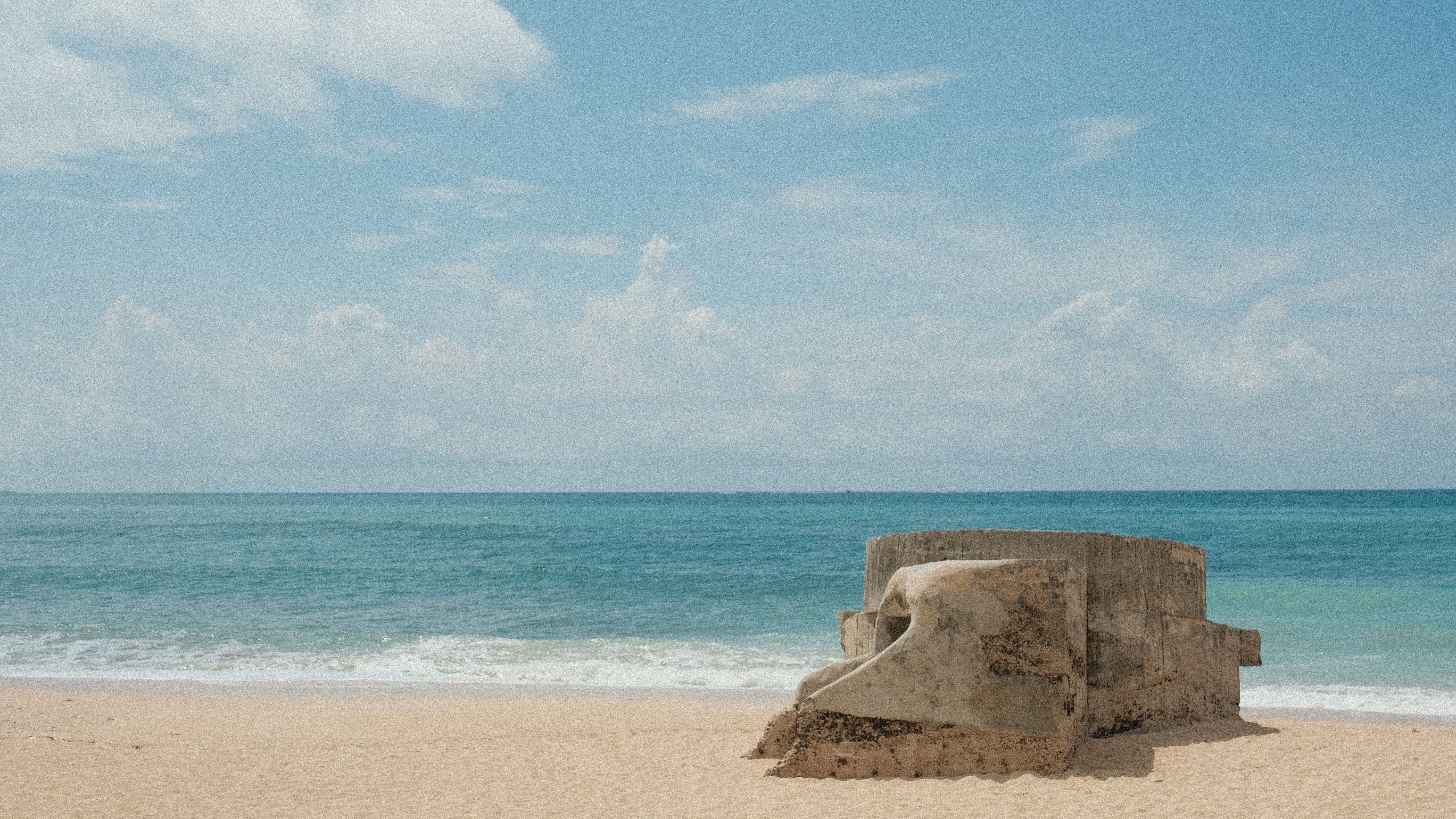 Idyllic beach scene in Taiwan featuring azure waters and a historic bunker.