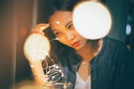 发光的串灯环绕着一位年轻女子的艺术肖像，营造出梦幻般的氛围